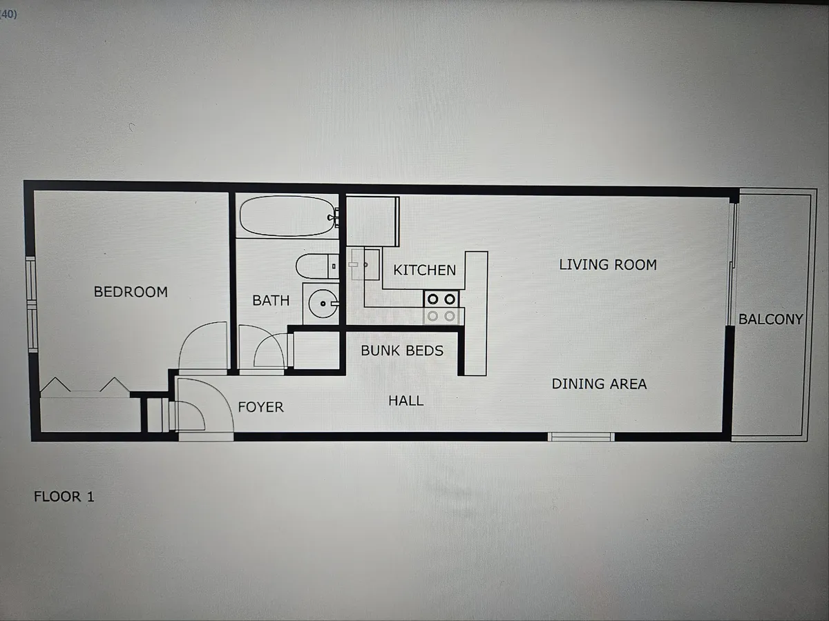A wide shot showing the open-plan kitchen, living room, bunk beds, dining area, and balcony. Natural light streams in from the balcony doors, illuminating designer finishes and luxury vinyl plank flooring. The scene feels cozy and family-friendly, with clear sightlines connecting the main living spaces.